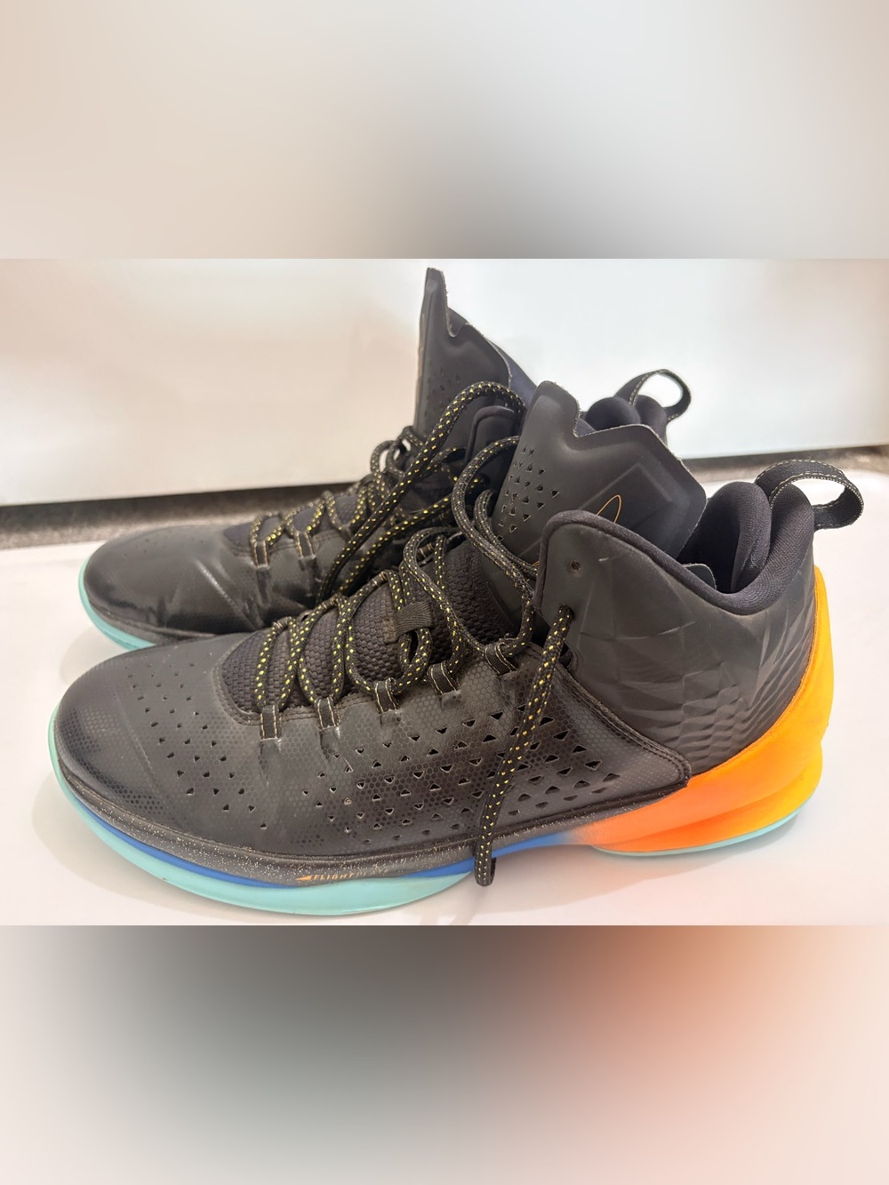Jordan Melos Mens Black High-Top Sneakers with Orange Heel and Teal Sole